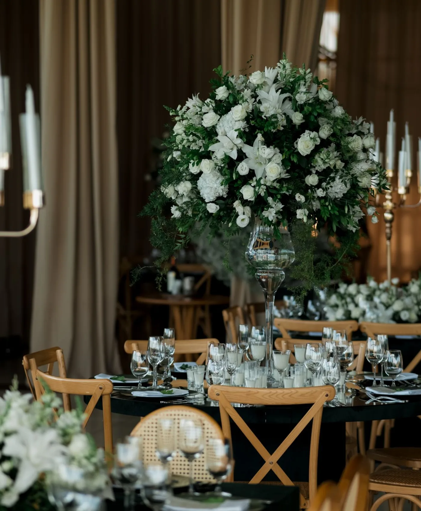 Sculptural white floral arrangement in a candlelit dining room