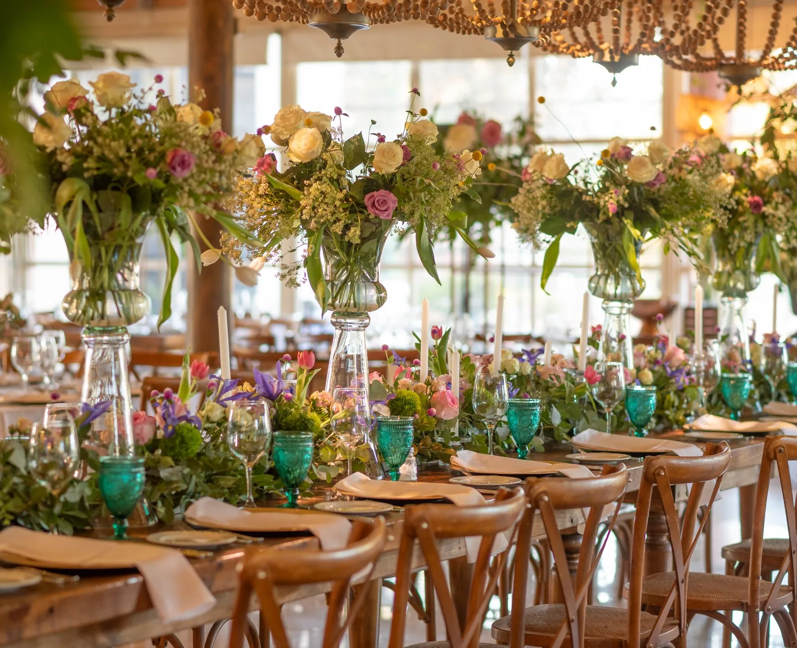 Sunlit tablescape with colorful glassware and abundant spring flowers
