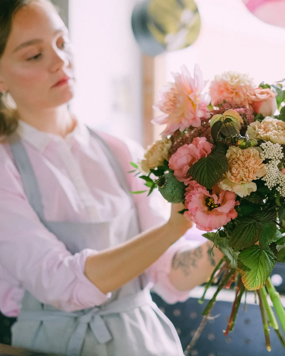 A florist holding a fresh garden-style bouquet