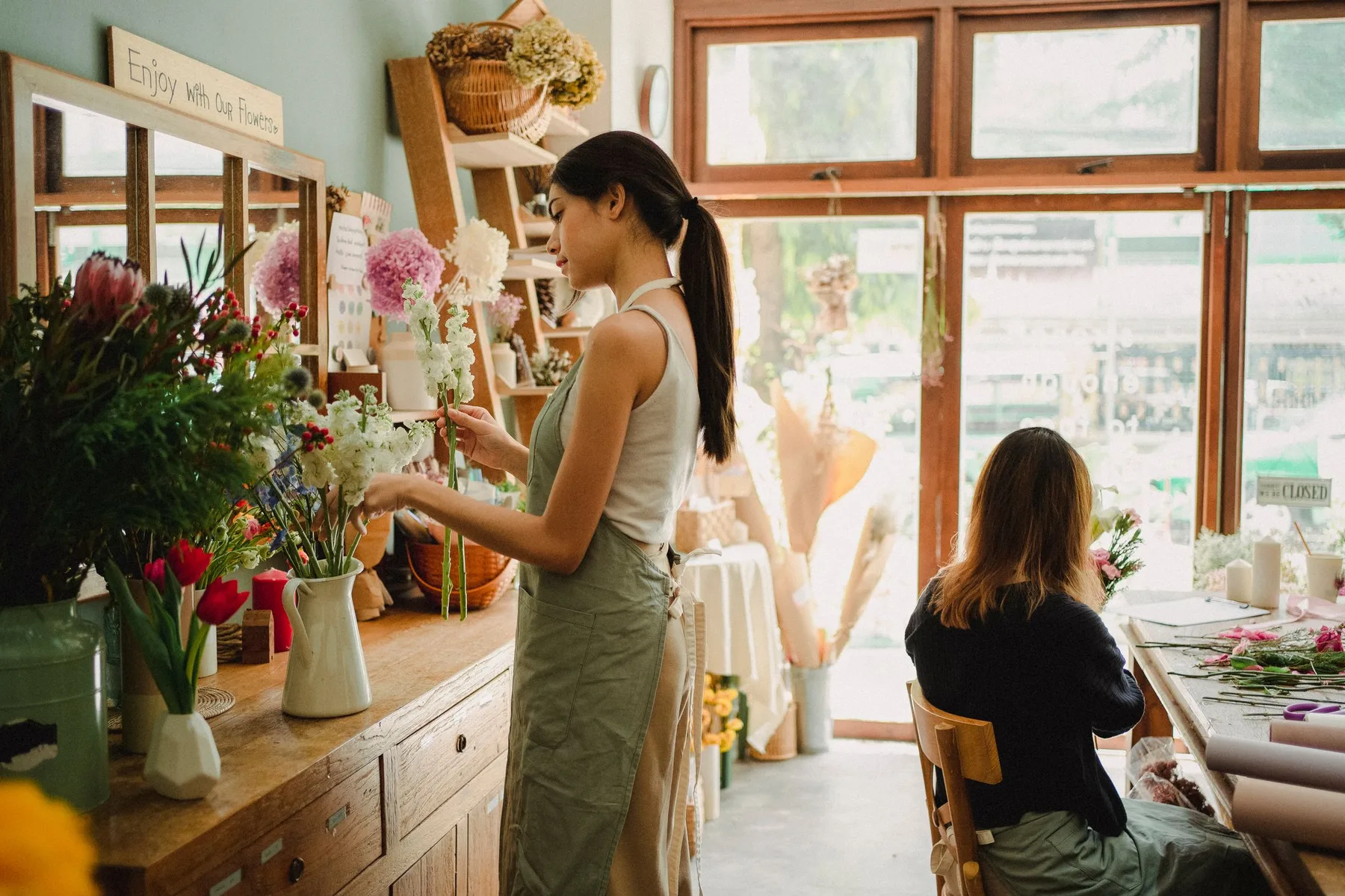 Florists at work in a sunlit neighborhood flower studio